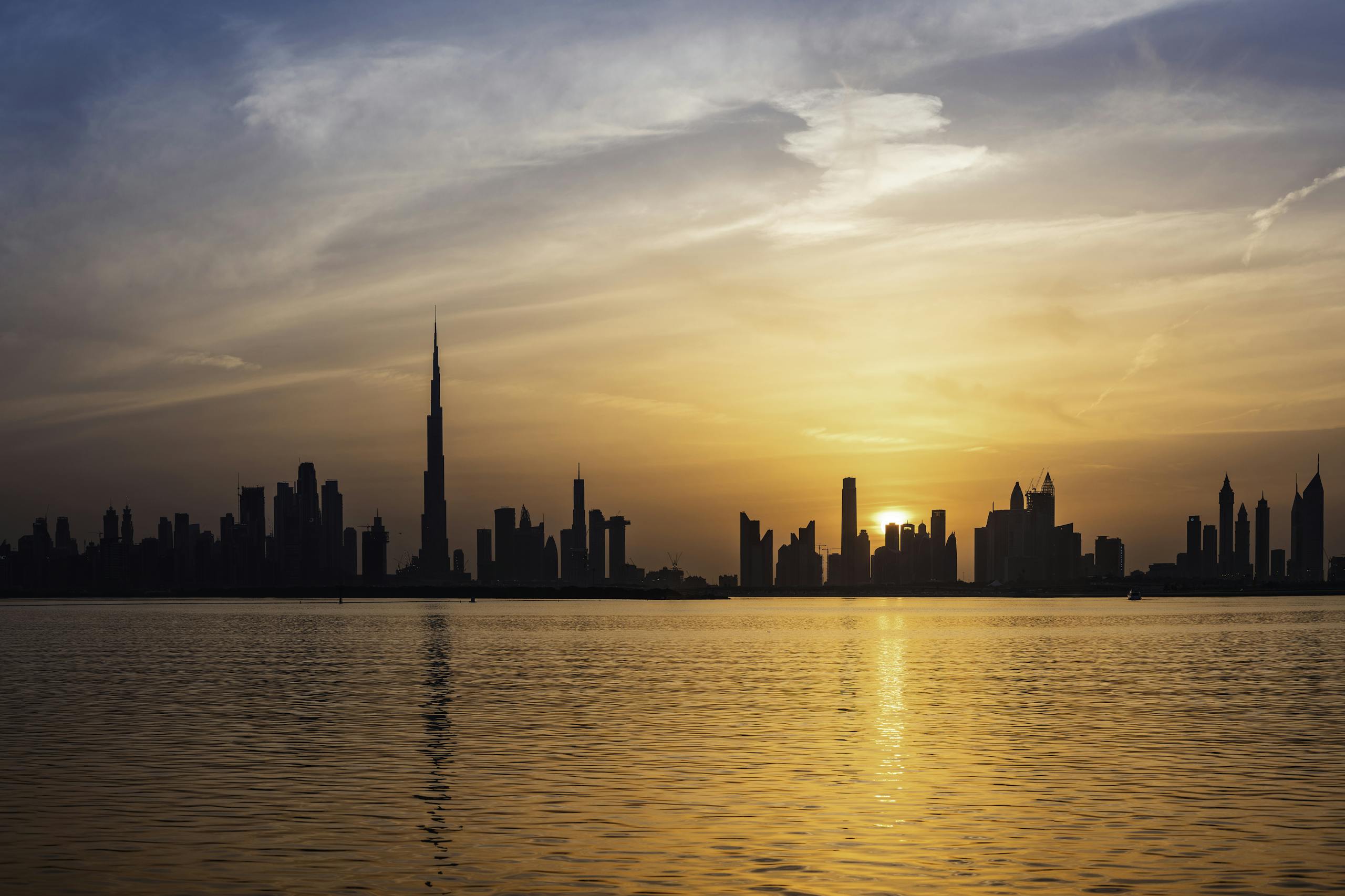Enchanting view of Dubai's skyscrapers at sunset with the iconic Burj Khalifa outlined against the vivid sky.