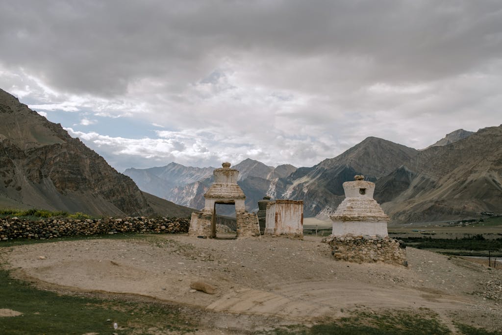 Peaceful view of ancient Buddhist stupas set against the dramatic mountains in Zanskar Valley.