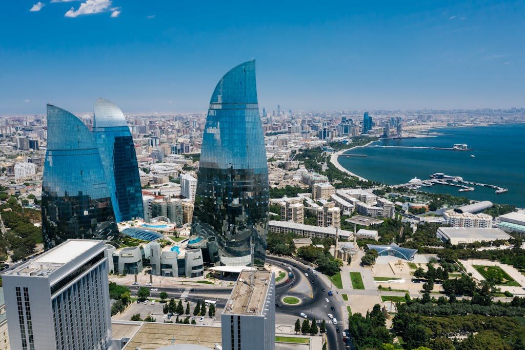 Stunning aerial view of Baku's Flame Towers with the Caspian Sea in the backdrop.